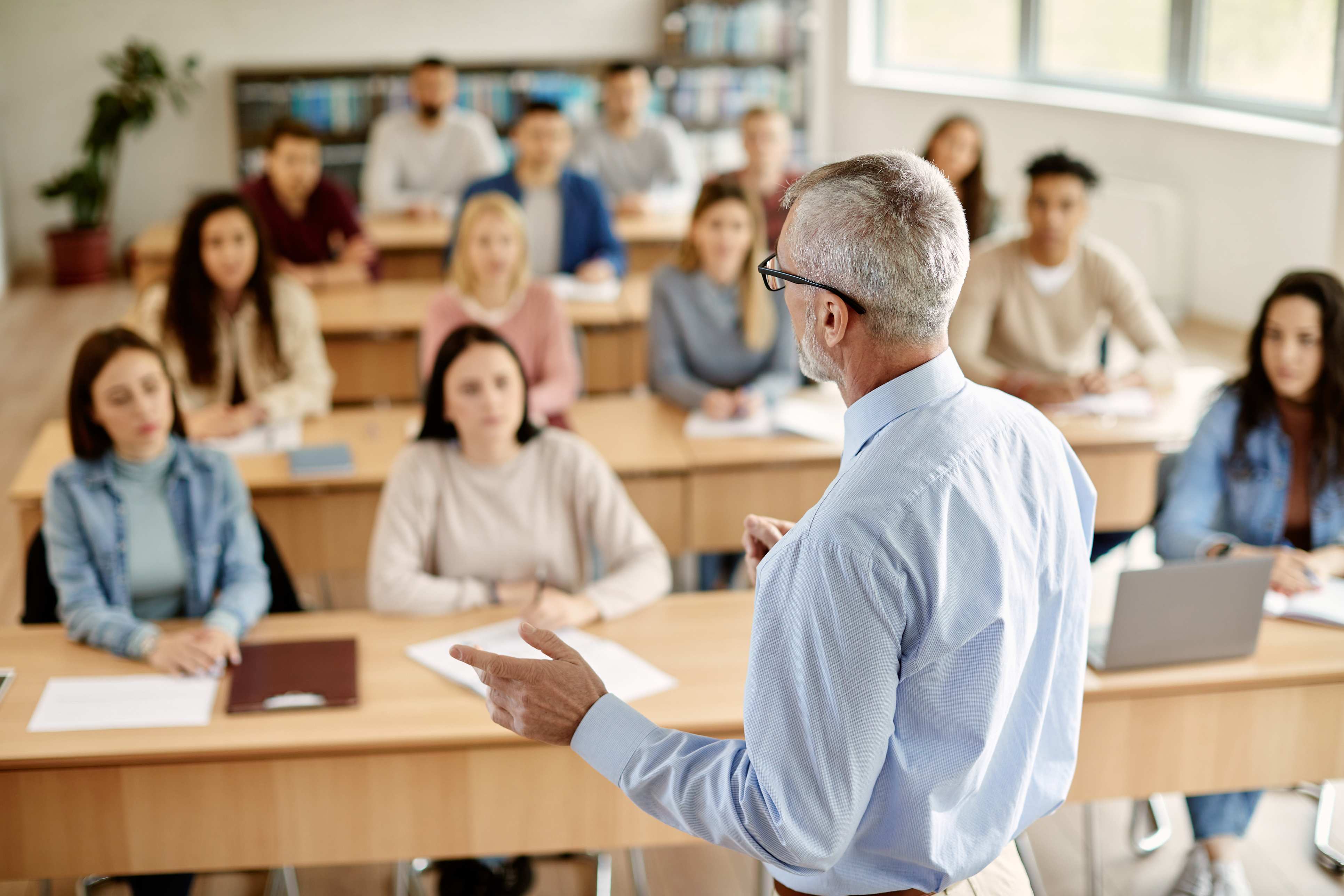 Professor falando em sala de aula. Letramento Acadêmico: tessituras do texto/discurso em dissertações e teses